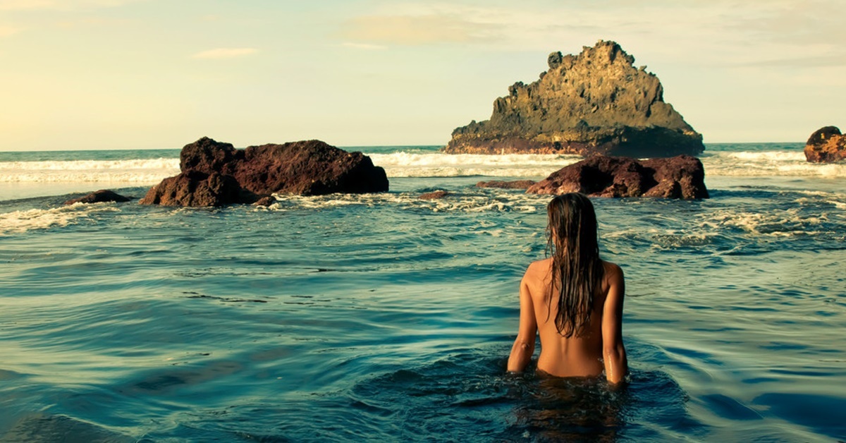 mujer nadando en la playa